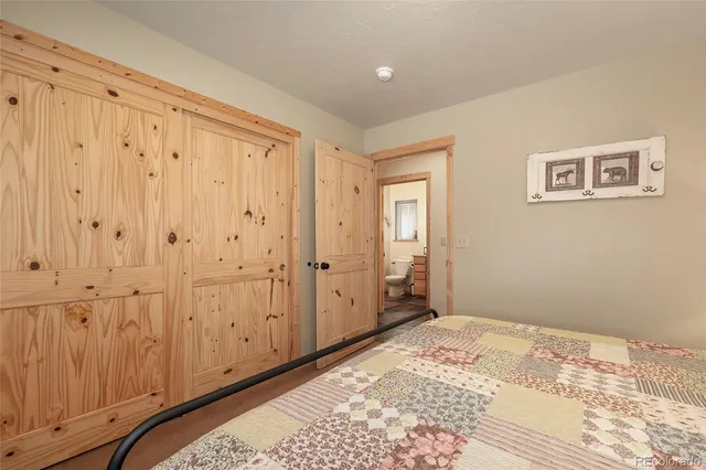 a view of a bedroom with wooden floor and bathroom