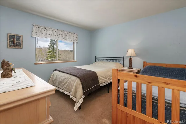 a bedroom with a bed a window and dresser