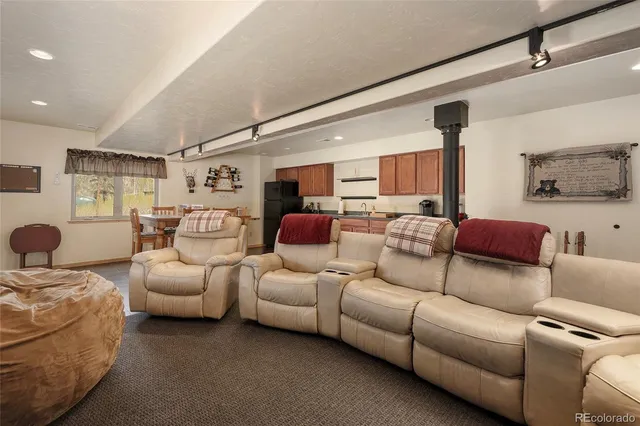 a living room with furniture kitchen view and a window