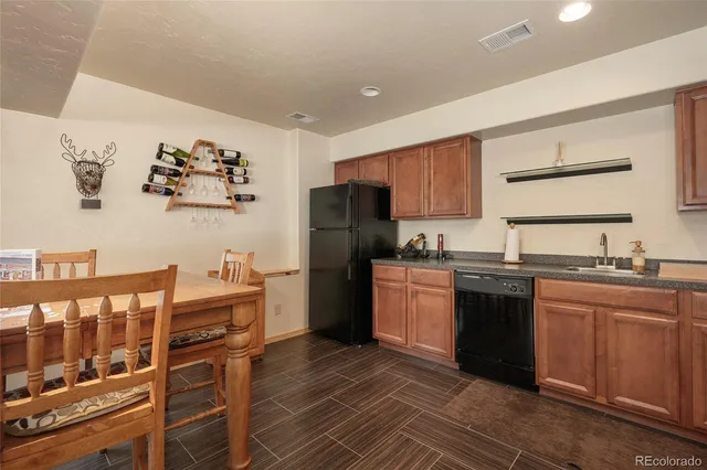 a kitchen with granite countertop a refrigerator stove top oven and sink