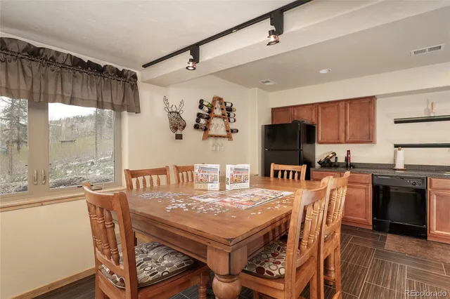 a kitchen with stainless steel appliances granite countertop a stove a refrigerator a kitchen island a dining table and chairs