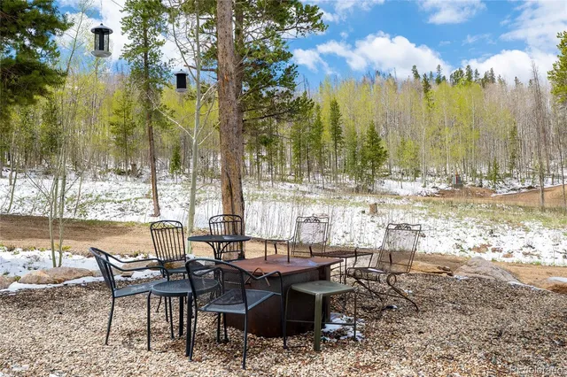 a view of a patio with table and chairs and floor to ceiling window