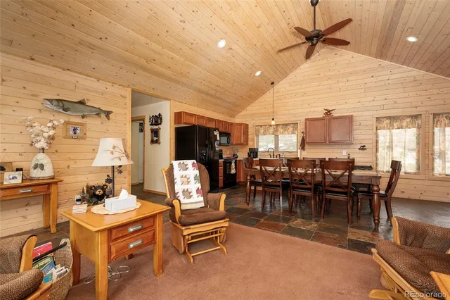 a dining hall with stainless steel appliances kitchen island granite countertop furniture and a kitchen view