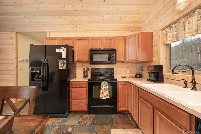a kitchen with stainless steel appliances granite countertop a refrigerator and a stove top oven