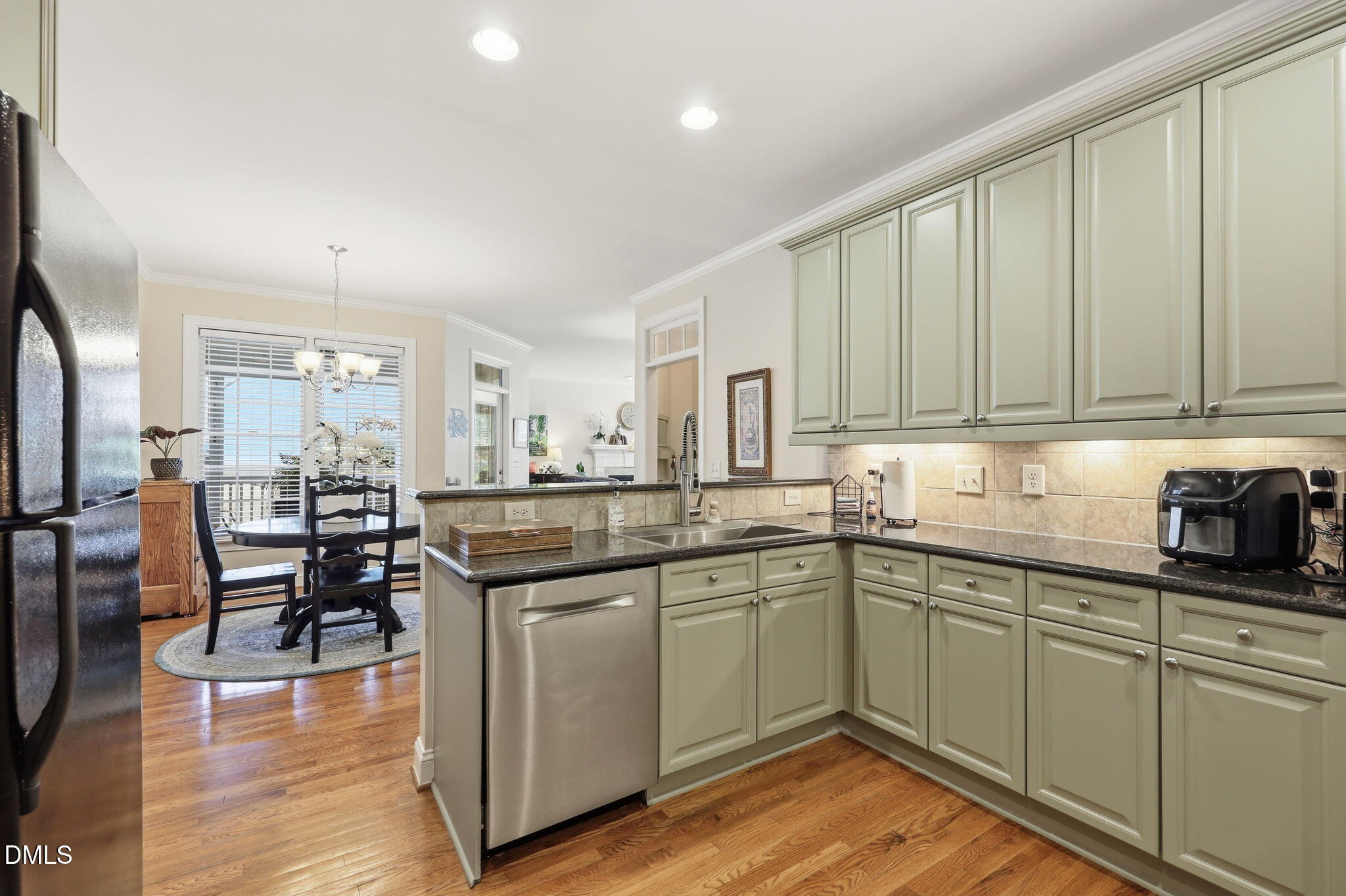7040 Dayton Ridge Drive Apex, NC 27539 - Photo 14 of 38 a kitchen with stainless steel appliances granite countertop a table chairs sink and cabinets