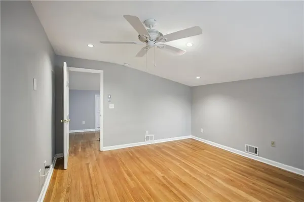 a view of empty room with wooden floor