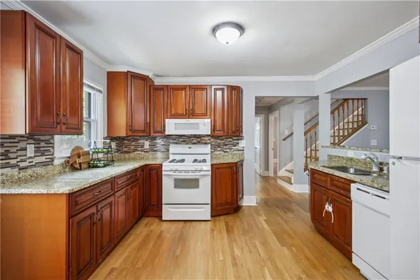 a kitchen with stainless steel appliances granite countertop a stove a sink dishwasher and a refrigerator