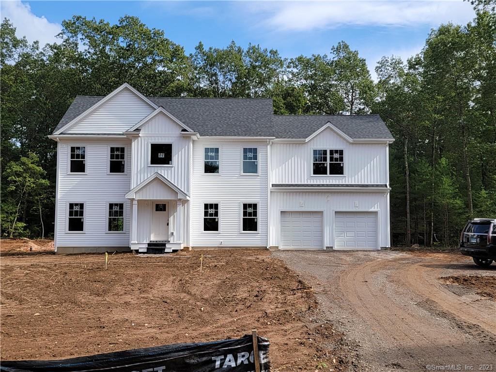 a front view of a house with a yard and trees