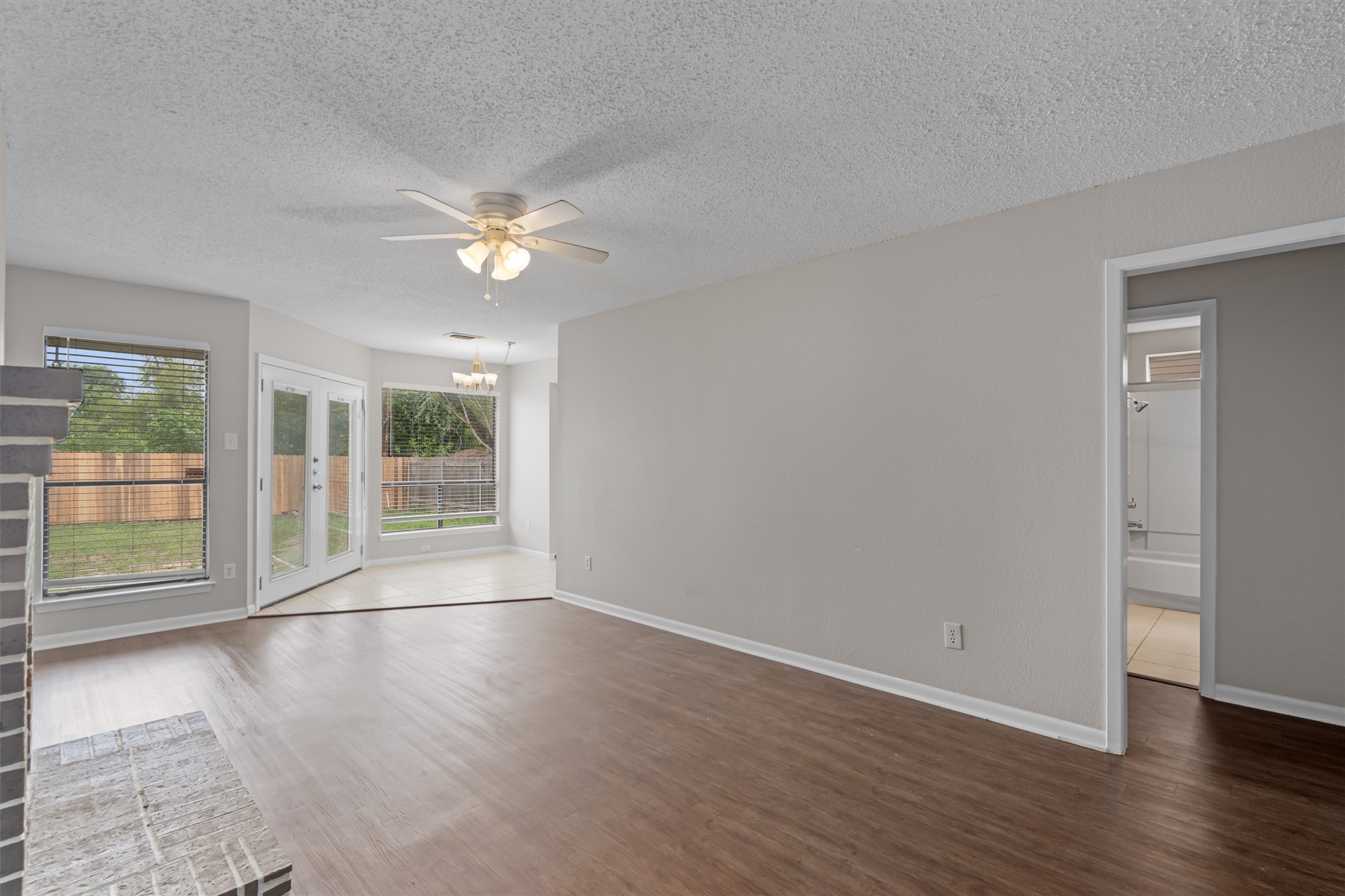 a view of an empty room with window and wooden floor