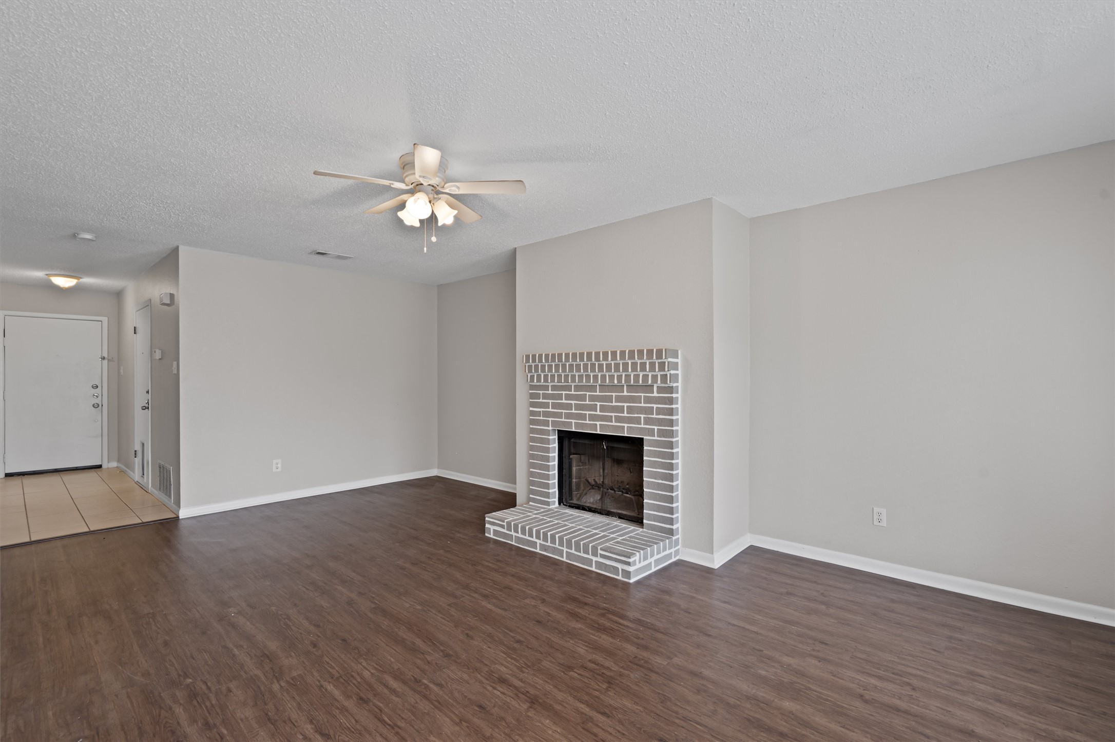 13357 Water Oak Lane, Unit A Austin, TX 78729 - Photo 3 of 26 a view of an empty room with wooden floor fireplace and a window