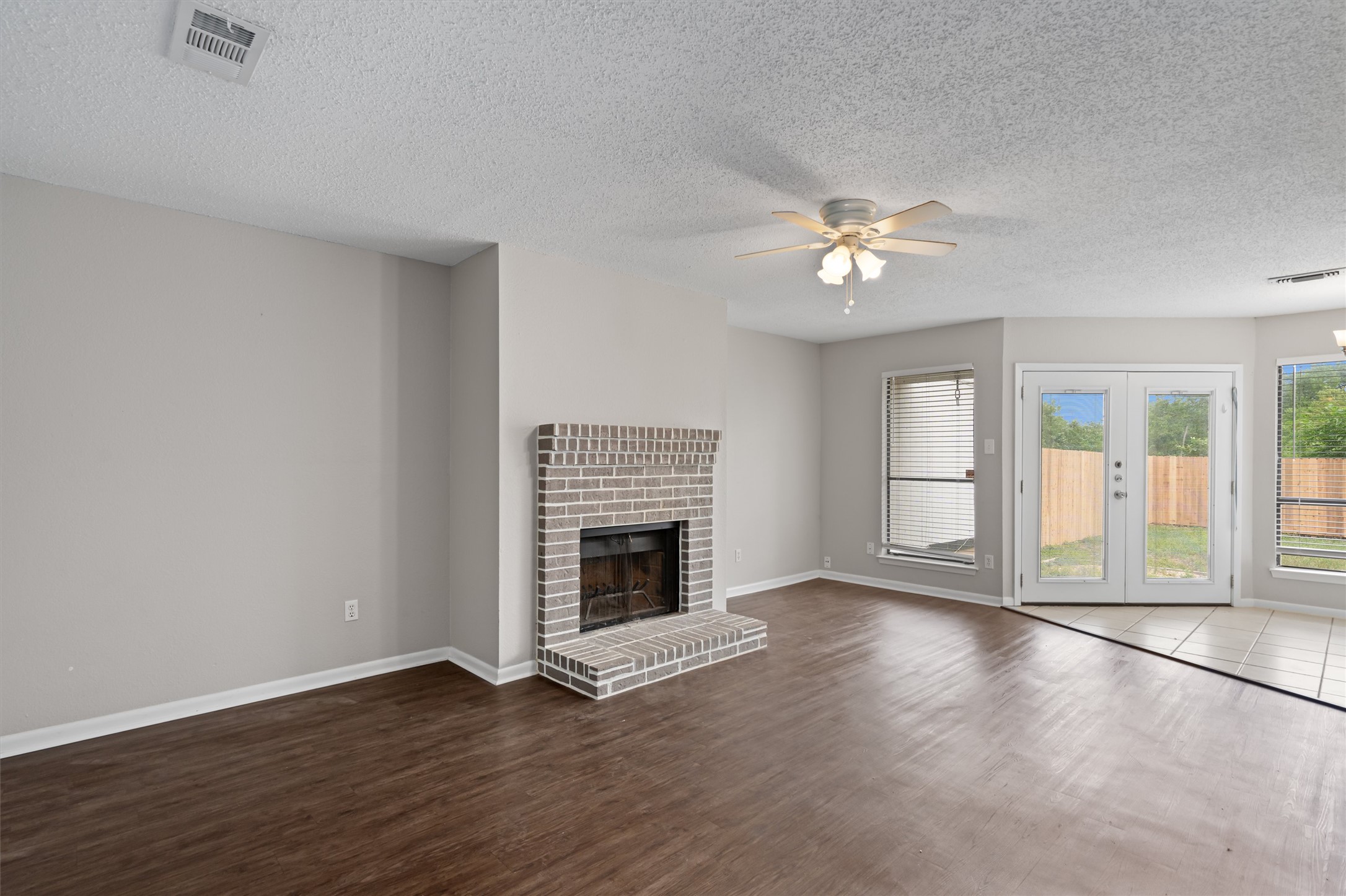 13357 Water Oak Lane, Unit A Austin, TX 78729 - Photo 4 of 26 an empty room with fireplace fan and windows