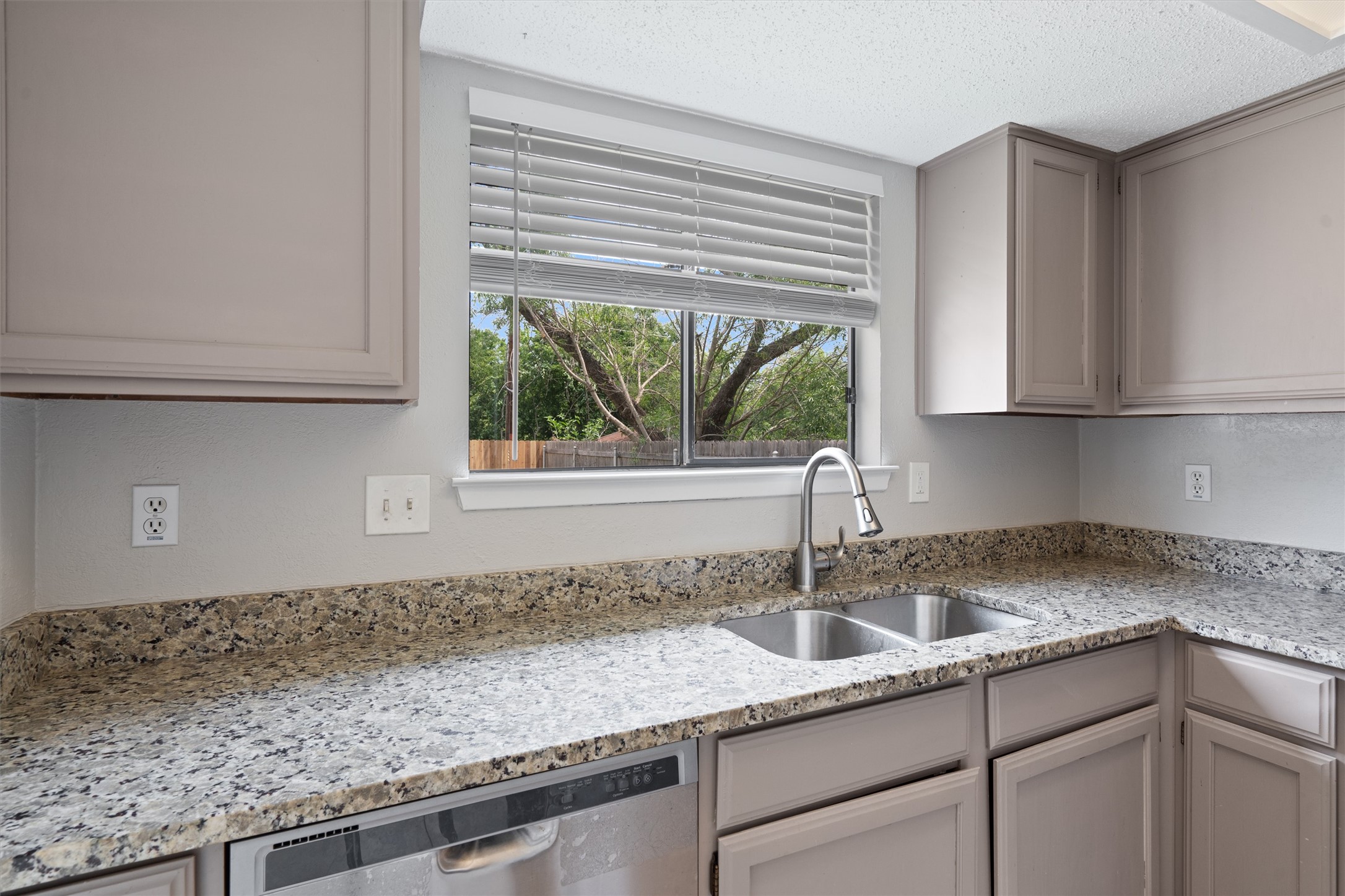 13357 Water Oak Lane, Unit A Austin, TX 78729 - Photo 7 of 26 a kitchen with stainless steel appliances granite countertop a sink and a white cabinets next to a window