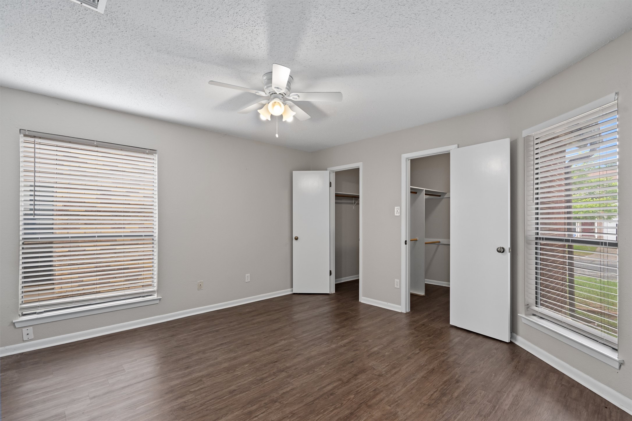 13357 Water Oak Lane, Unit A Austin, TX 78729 - Photo 9 of 26 an empty room with wooden floor chandelier fan and windows