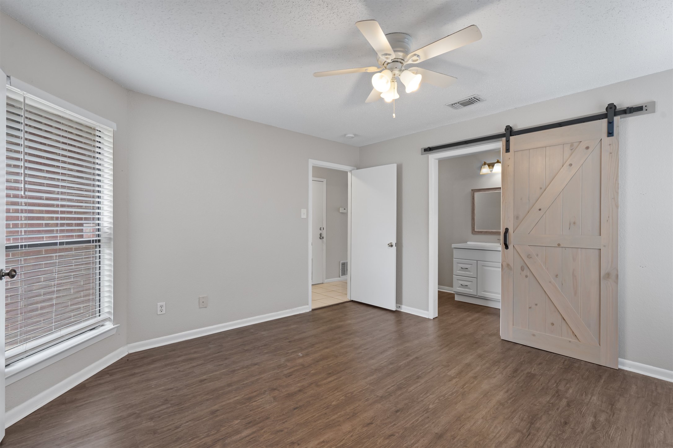 13357 Water Oak Lane, Unit A Austin, TX 78729 - Photo 10 of 26 a view of an empty room with wooden floor and a window