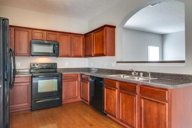 a kitchen with stainless steel appliances granite countertop a stove microwave and sink