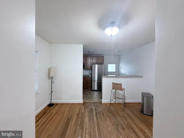 a view of a kitchen with wooden floor and a refrigerator