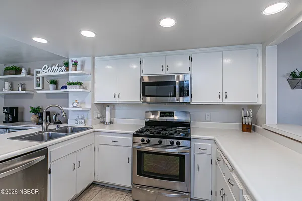 a kitchen with cabinets stainless steel appliances and sink