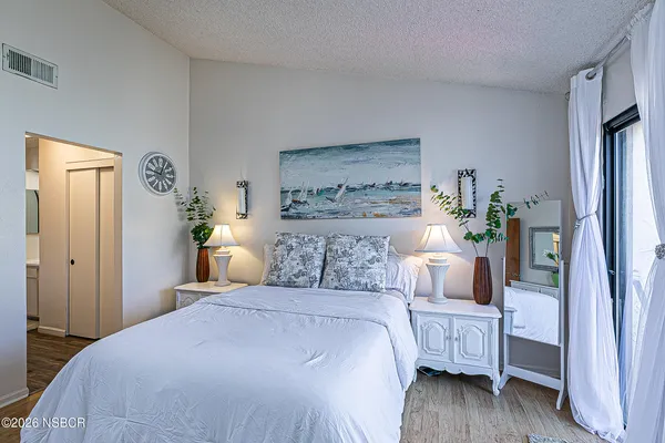 a bedroom with a bed and wooden floor