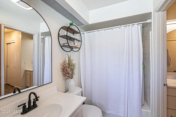 a bathroom with a sink and mirror with toilet