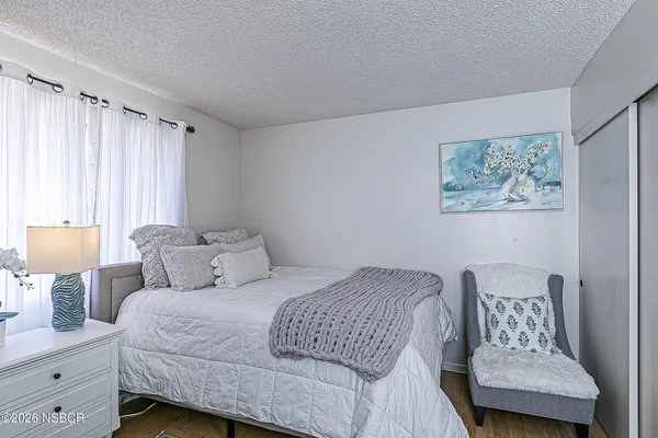 a bedroom with a bed and a lamp on dresser