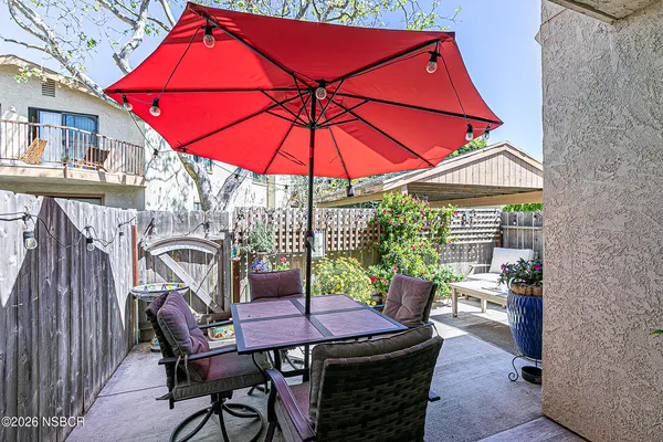 a patio with a table and chairs under an umbrella