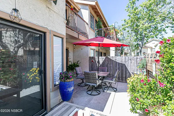 a view of a table and chairs in patio in front of a house
