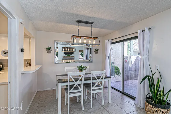 a dining room with furniture a chandelier and wooden floor