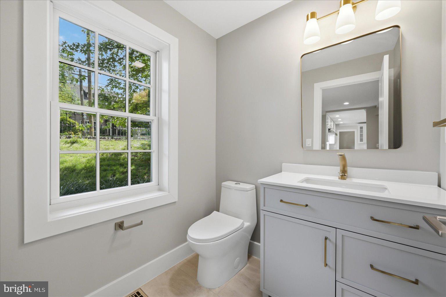 3517 Rodman Street Northwest Washington, DC 20008 - Photo 18 of 57 a bathroom with a toilet a sink a vanity and a window