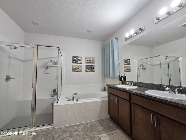 a bathroom with a tub sink shower and mirror