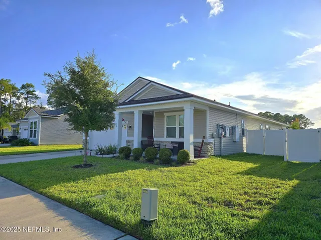 a view of a house with a yard and pathway
