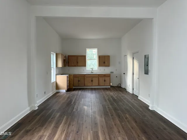 a view of a big room with wooden floor and windows