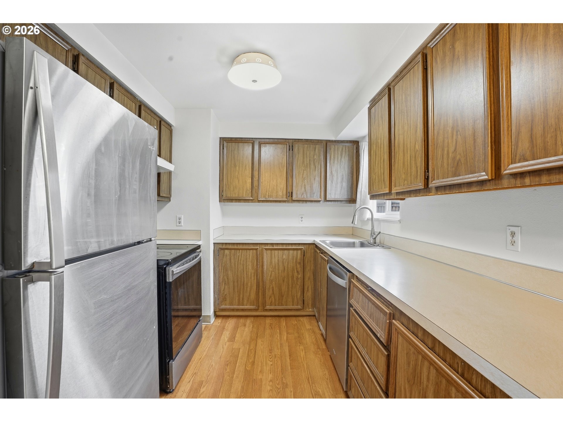 3537 Southeast 64th Avenue Portland, OR 97206 - Photo 12 of 32 a kitchen with a sink a refrigerator and cabinets