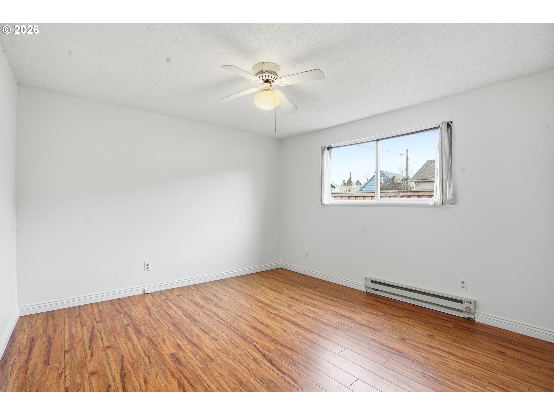 3537 Southeast 64th Avenue Portland, OR 97206 - Photo 16 of 32 an empty room with wooden floor ceiling fan and windows