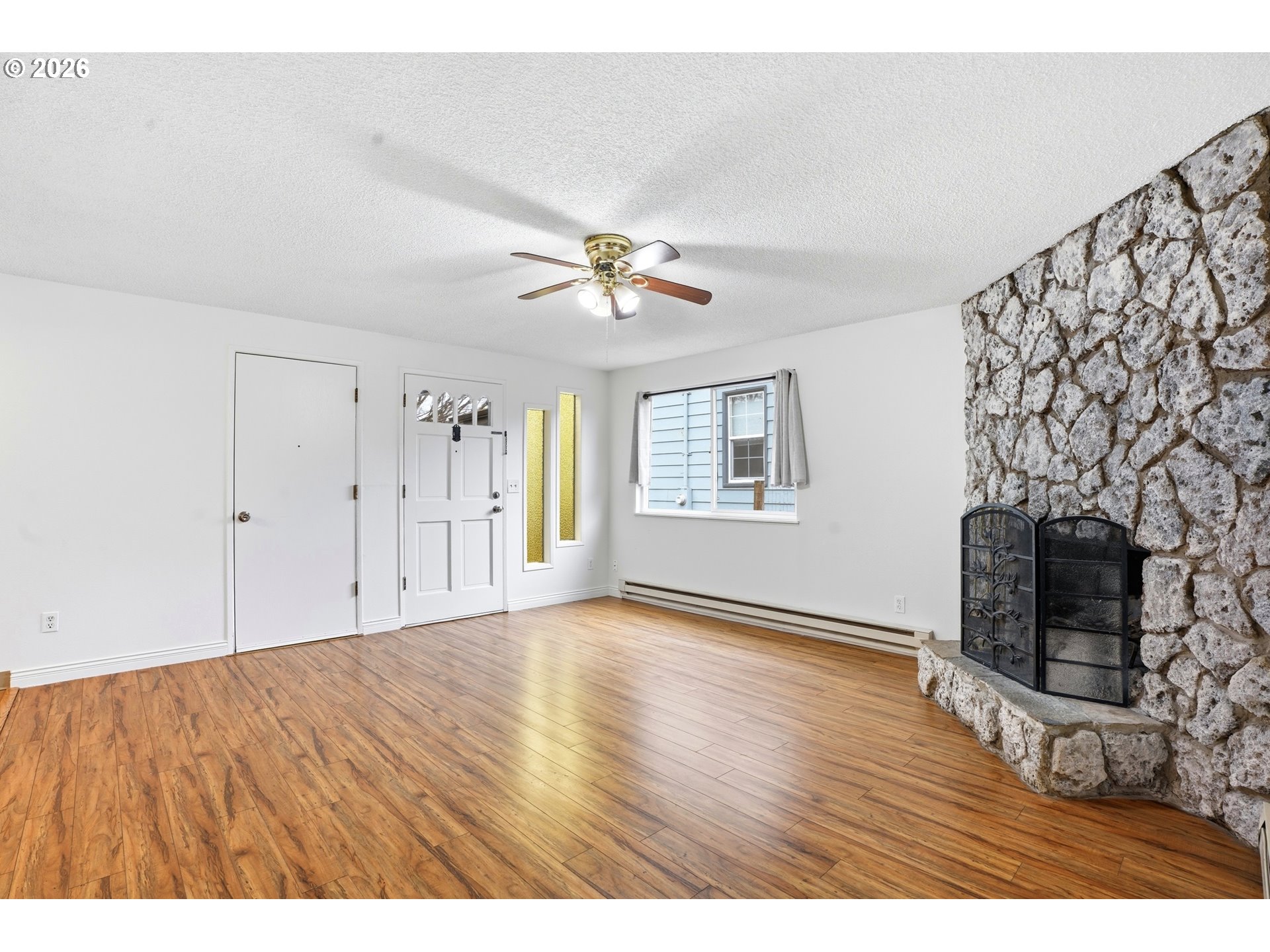 3537 Southeast 64th Avenue Portland, OR 97206 - Photo 6 of 32 a view of an empty room with a fireplace and wooden floor