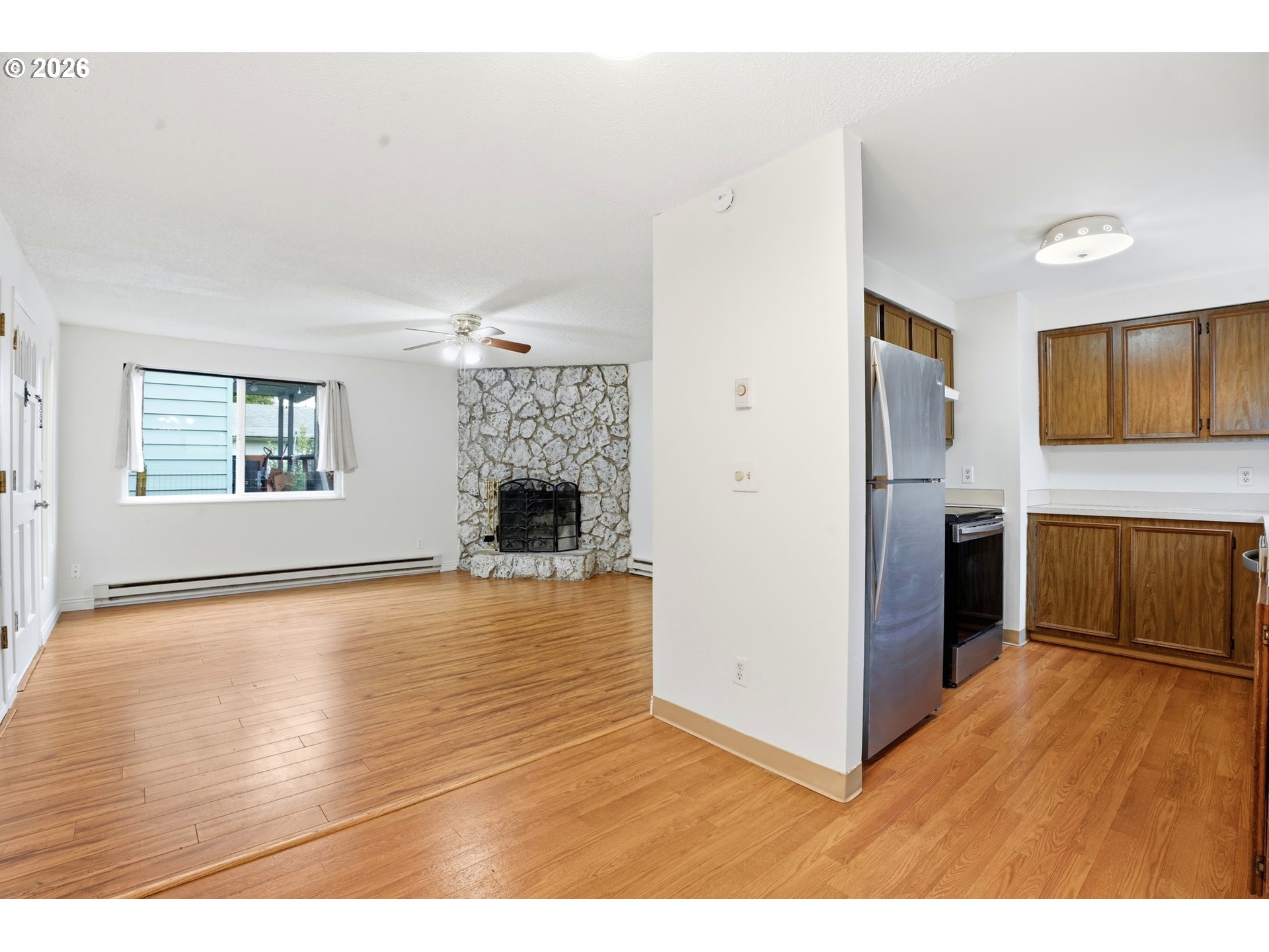 3537 Southeast 64th Avenue Portland, OR 97206 - Photo 9 of 32 a view of empty room with wooden floor and fireplace