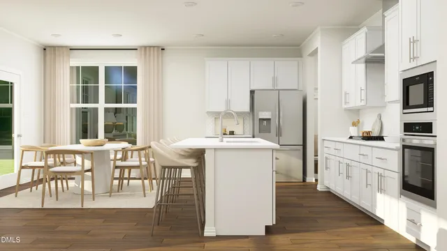 a kitchen with stainless steel appliances granite countertop a table chairs wooden floors and white cabinets