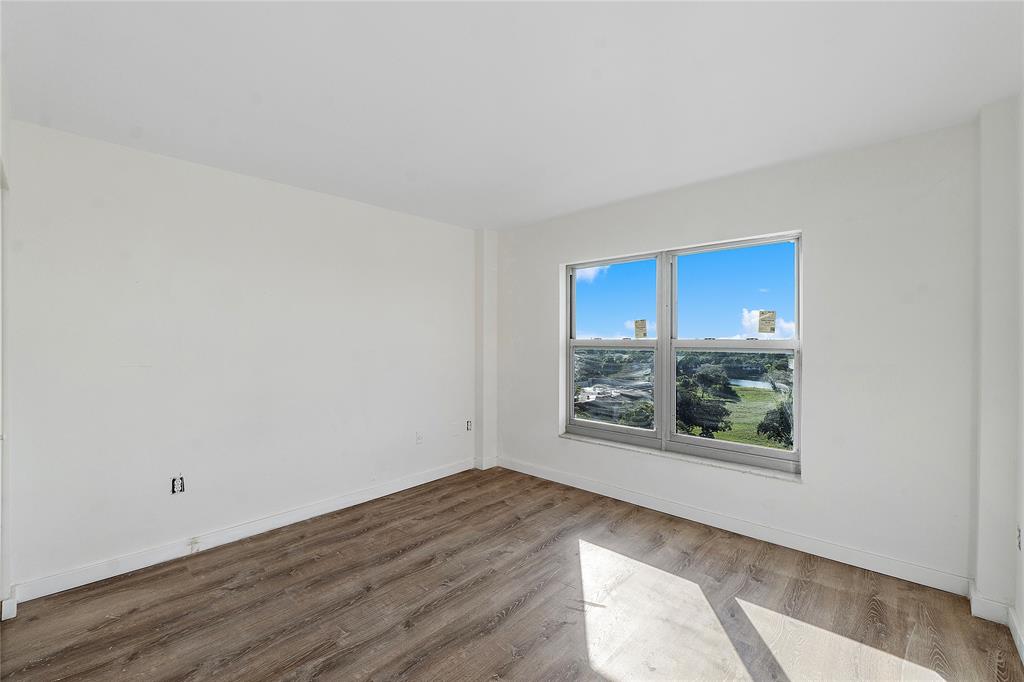 4174 Inverrary Drive, Unit 1002 Lauderhill, FL 33319 - Photo 16 of 28 an empty room with wooden floor and windows