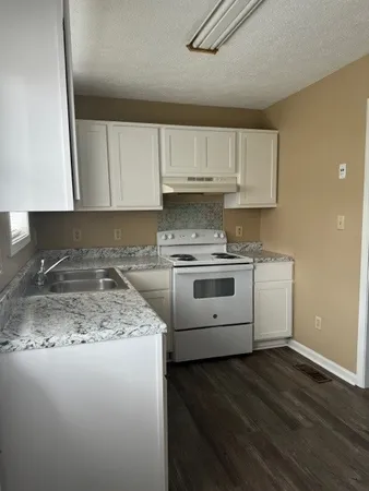 a kitchen with a sink stove and cabinets
