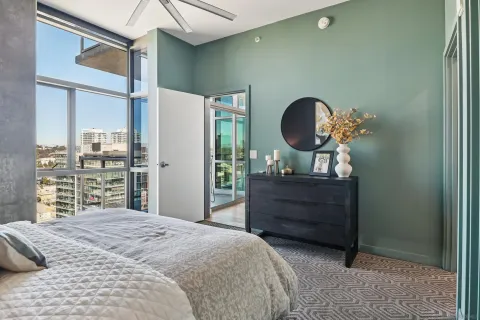 a bedroom with a bed mirror and a window