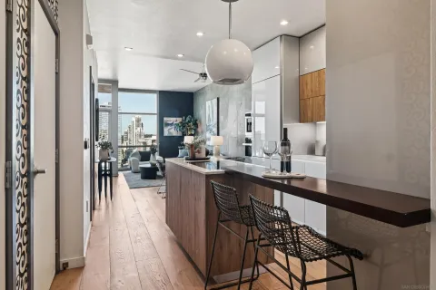a kitchen with stainless steel appliances a dining table chairs sink and cabinets
