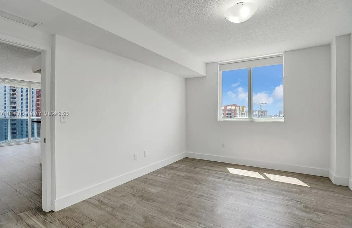 601 Northeast 23rd Street, Unit 1405 Miami, FL 33137 - Photo 12 of 23 an empty room with wooden floor and windows