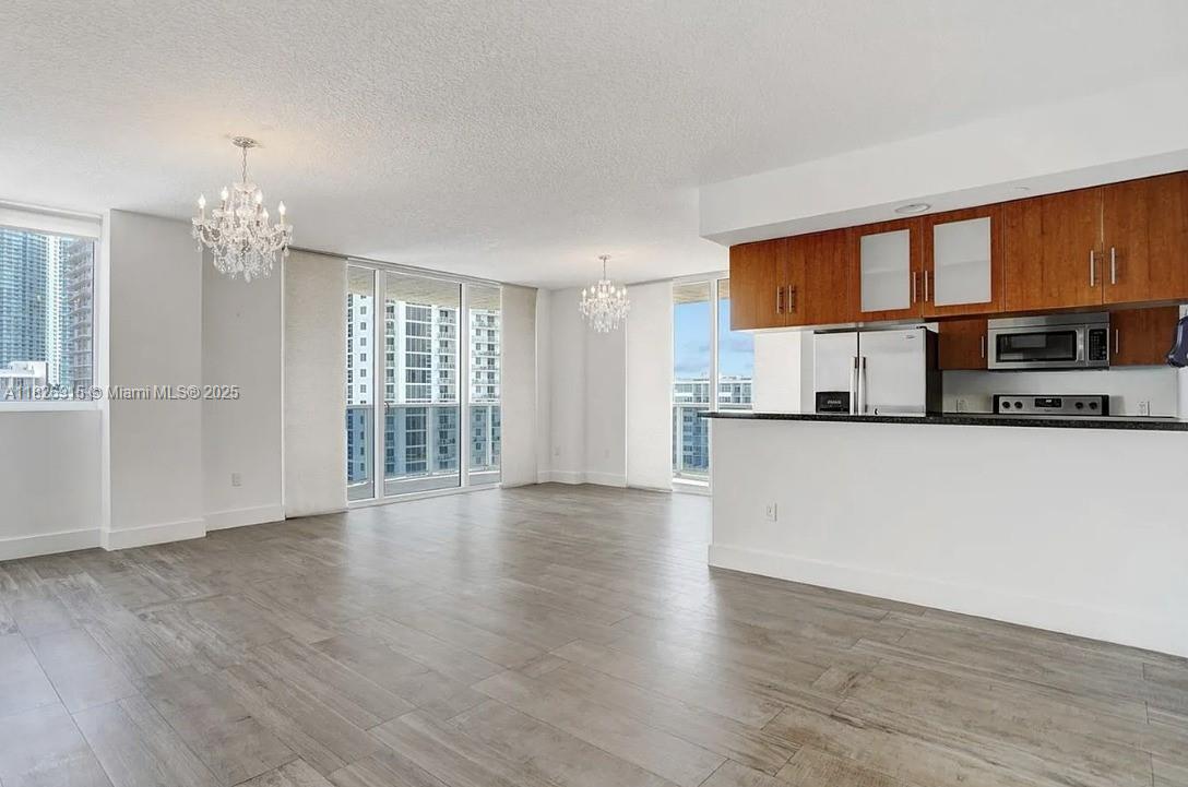 601 Northeast 23rd Street, Unit 1405 Miami, FL 33137 - Photo 6 of 23 a view of a kitchen with a sink and dishwasher a refrigerator with wooden floor