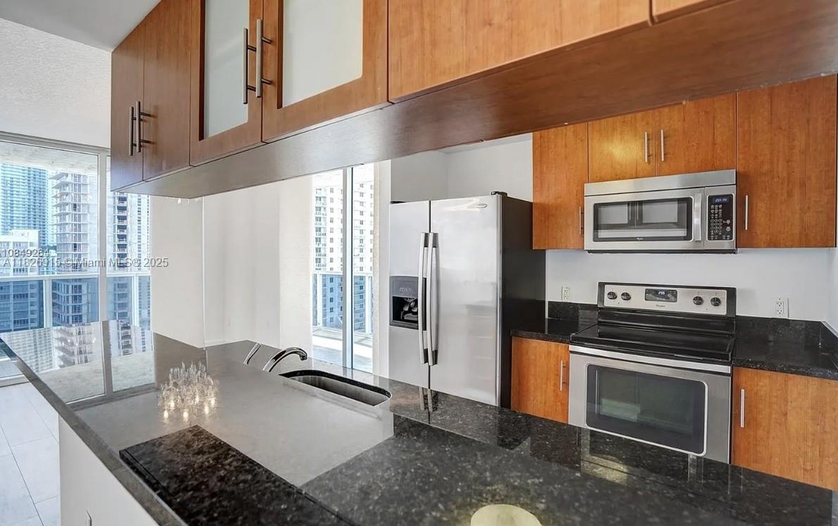 601 Northeast 23rd Street, Unit 1405 Miami, FL 33137 - Photo 10 of 23 a kitchen with stainless steel appliances granite countertop a refrigerator and a stove