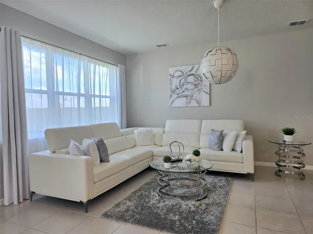 a living room with furniture chandelier and a window