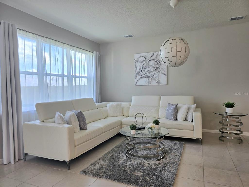 1973 Spring Shower Circle Kissimmee, FL 34744 - Photo 19 of 43 a living room with furniture chandelier and a window