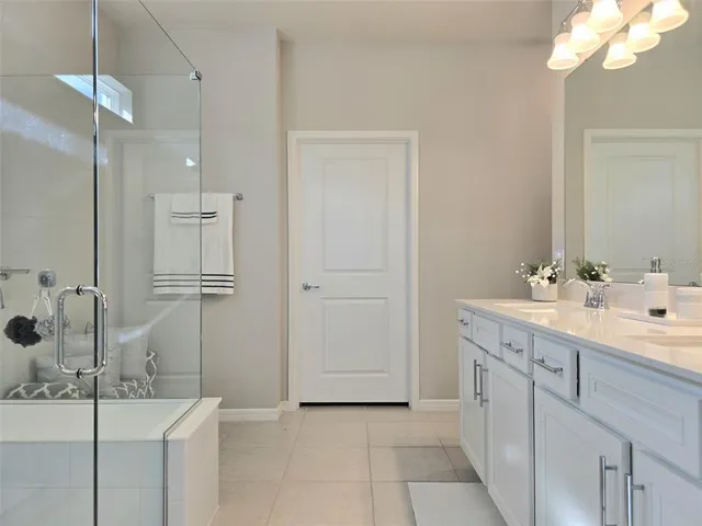a bathroom with a double vanity sink a mirror and shower