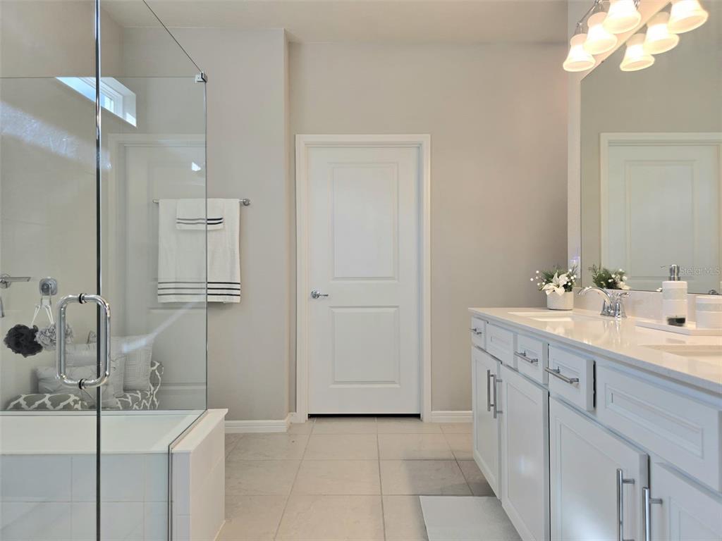 1973 Spring Shower Circle Kissimmee, FL 34744 - Photo 22 of 43 a bathroom with a double vanity sink a mirror and shower