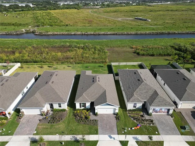 an aerial view of residential houses with outdoor space and a lake view