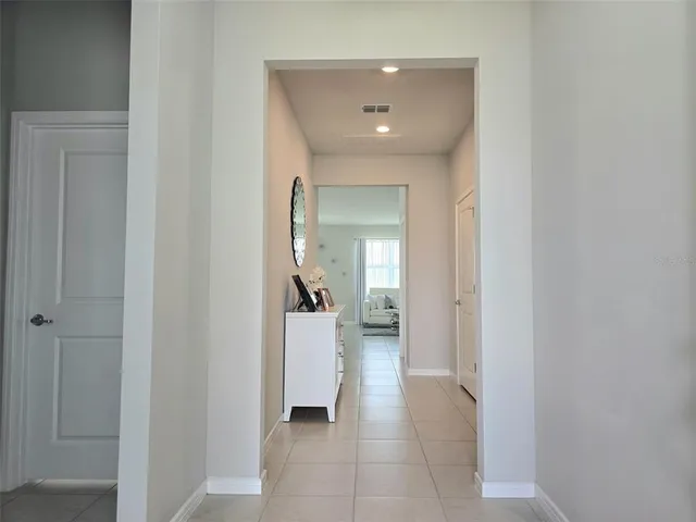 a view of a hallway with a livingroom and a bathroom