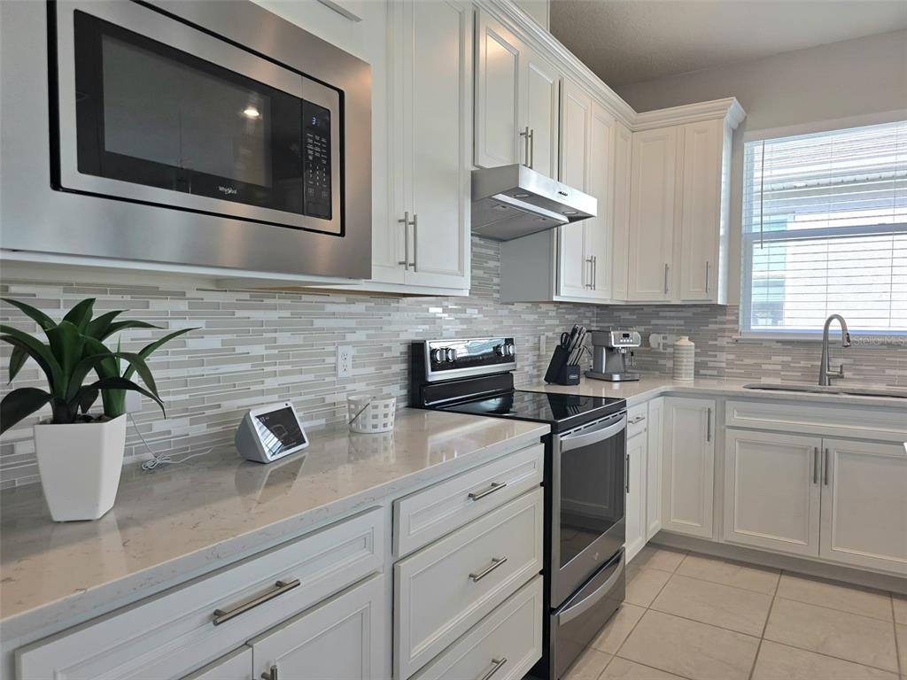 1973 Spring Shower Circle Kissimmee, FL 34744 - Photo 10 of 43 a kitchen with stainless steel appliances white cabinets white stove a sink and dishwasher